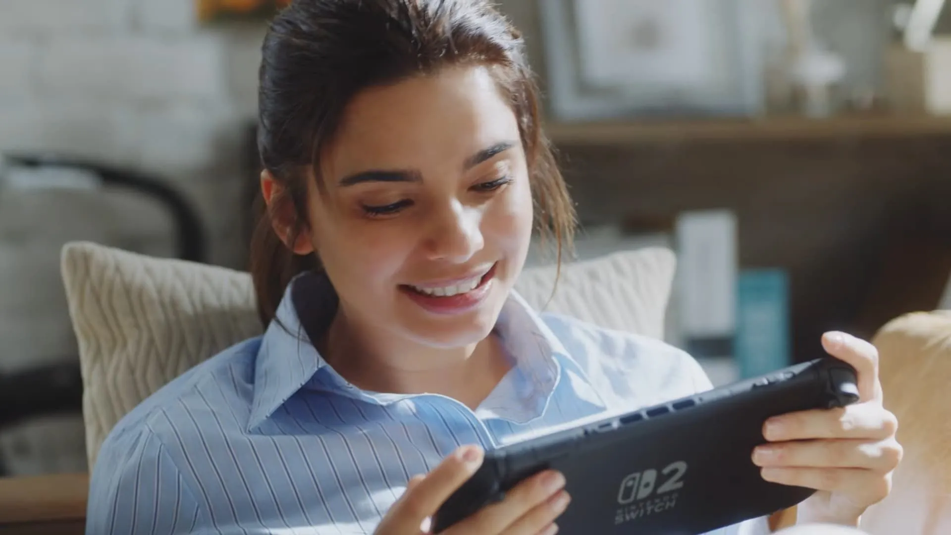 Một người đang chơi game trên Nintendo Switch 2 ở chế độ cầm tay trong một cuộc trò chuyện nhóm