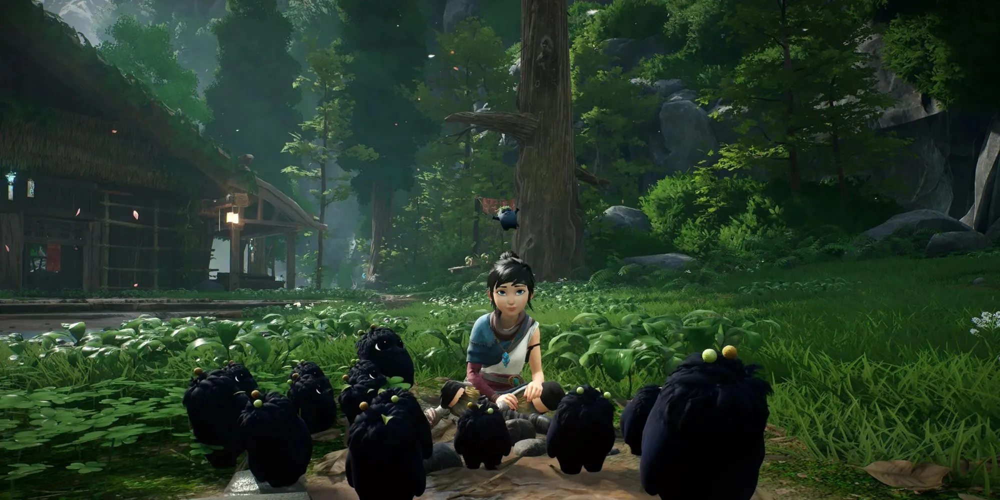 Kena đứng giữa các linh hồn Rot thân thiện trong game Kena: Bridge of Spirits