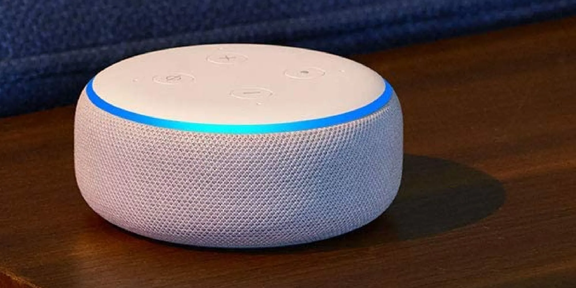 Thiết bị Amazon Alexa màu trắng đặt trên bề mặt gỗ, đại diện cho trợ lý ảo thông minh phong cách gamer.