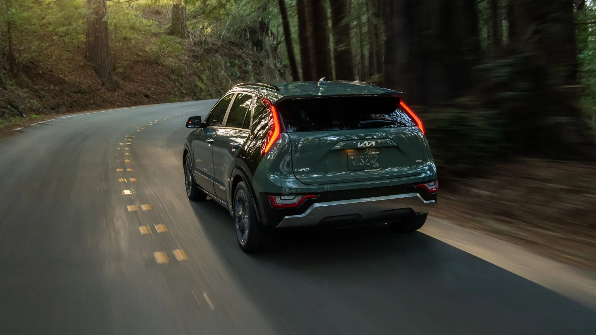 Góc nhìn sau 3/4 của Kia Niro 2025 trên đường, thể hiện thiết kế thân xe và mảng C-pillar