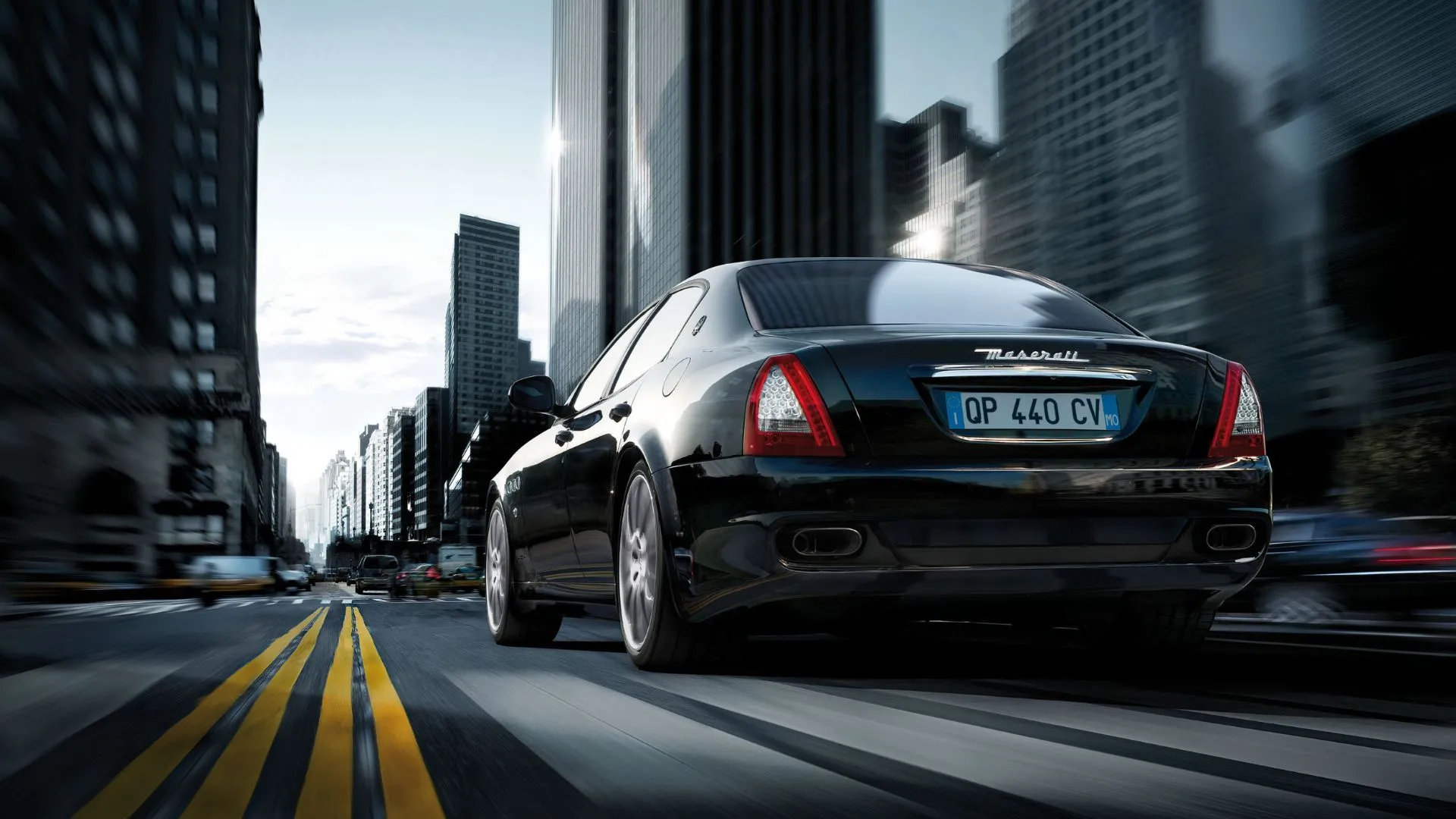 Maserati Quattroporte 2008 di chuyển trên đường phố, góc rear 3/4, nhấn mạnh cảm giác năng động và hiệu suất.